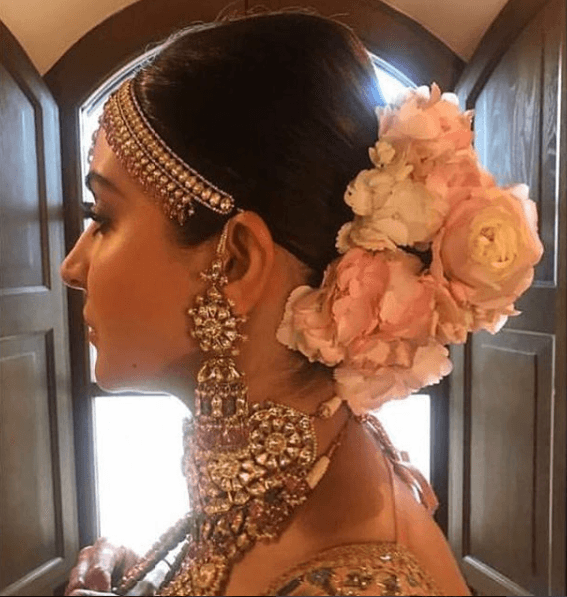 Anushka Sharma Hairstyles - Bun accessorized with flowers and maang tika